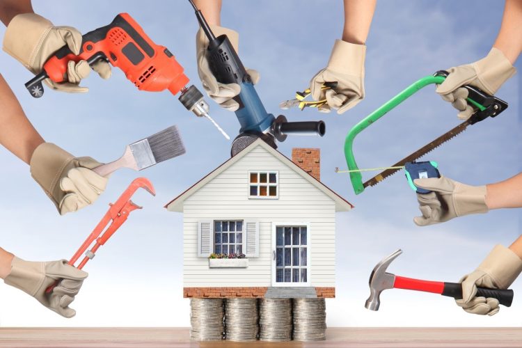 Multiple hands holding various tools circling a house.